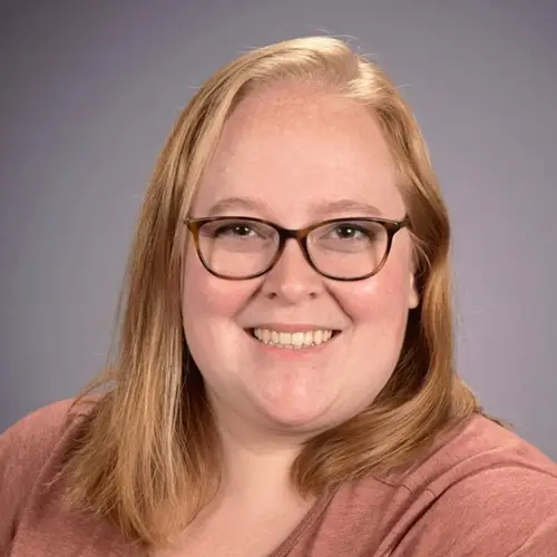 a woman with glasses smiling